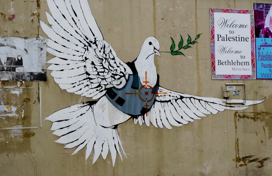 Muurschildering van een vredesduif met kogelwerendvest, op de illegale scheidingsmuur in Bethlehem.